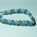 Βραχιόλι με ακρυλικό γαλάζιο κρύσταλλο και μαργαριταρακι σε συνδιασμο χρυση γυαλινη μικρη πετρουλα